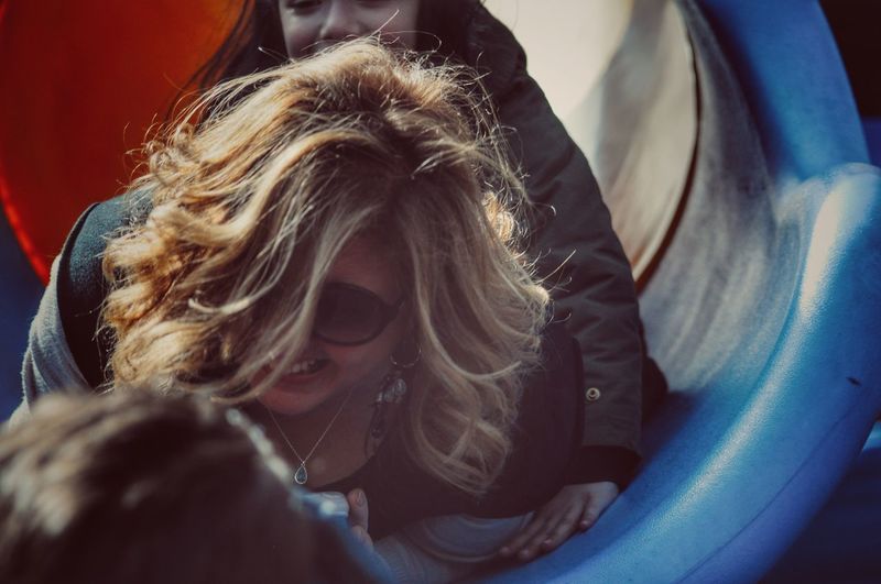 Low angle view of grandmother with granddaughter sliding in slide
