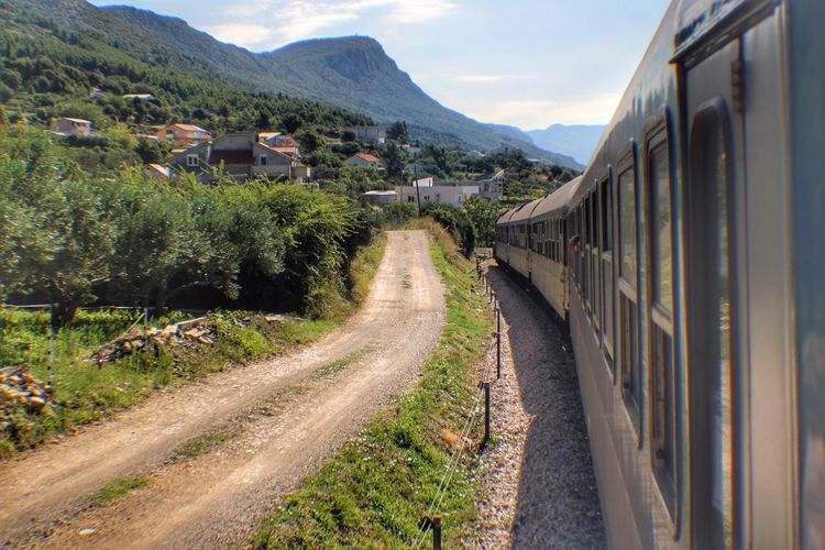 Panoramic view of railroad tracks amidst buildings and mountains