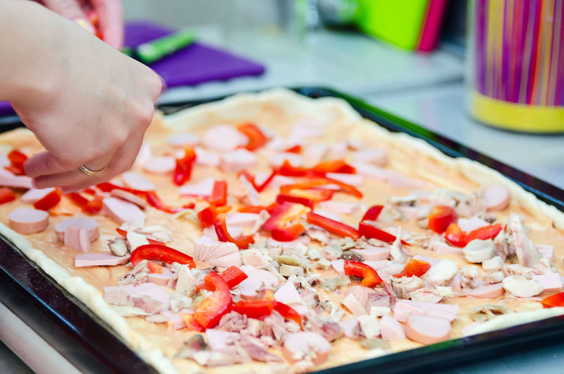 Close-up of person making pizza