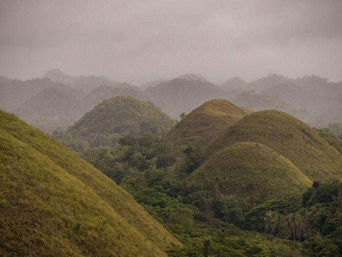 Scenic view of the chocolate hills against misty sky