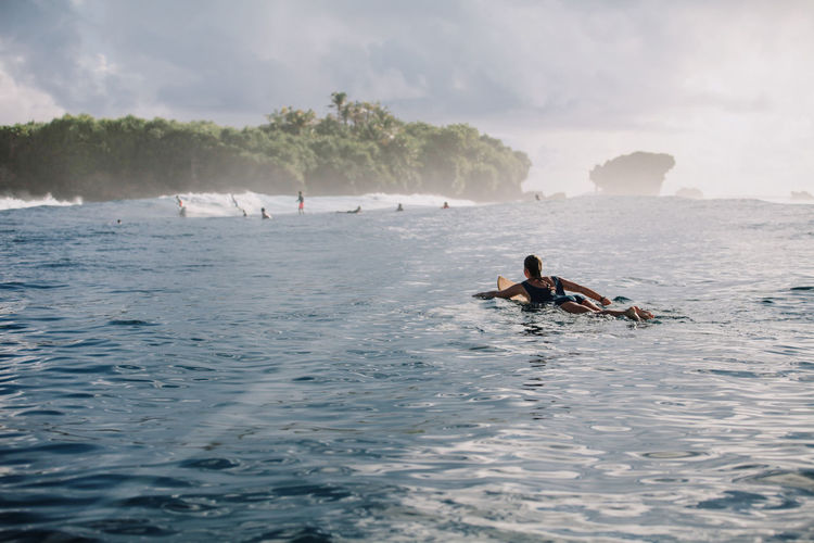 Woman on surfboard on the sea, siargao island, philippines