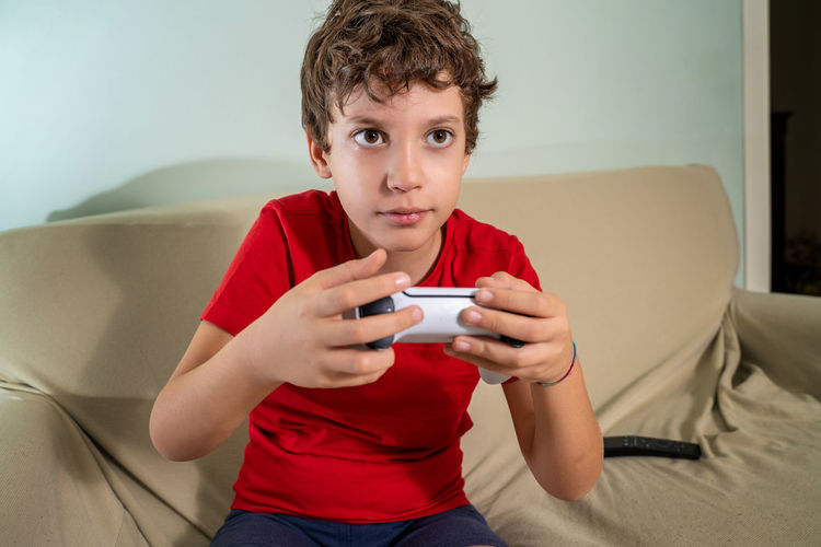 Portrait of boy sitting on sofa at home