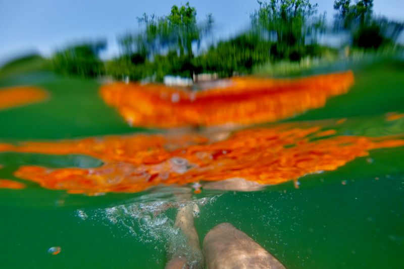 Low section of person swimming underwater