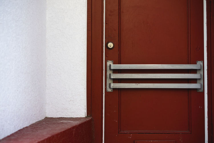 Red door with metal railing.