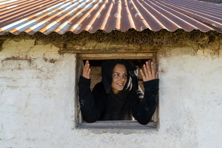 Young woman observes behind the window