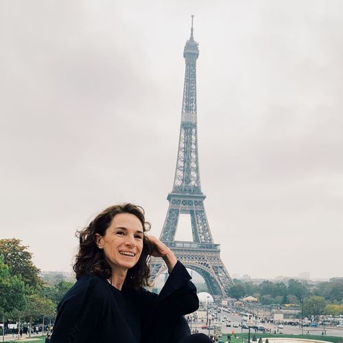 Smiling woman against eiffel tower in city