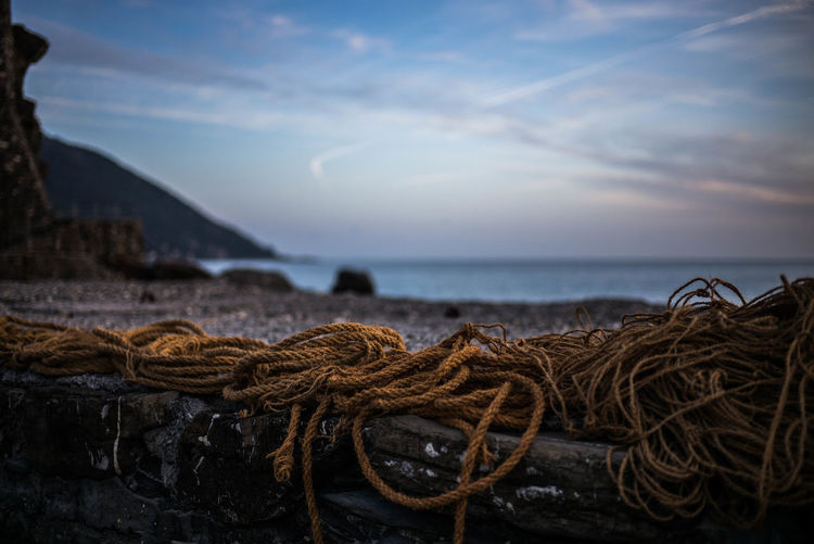 Close-up of fishing net on beach against sky