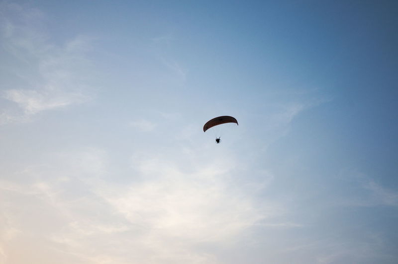 Low angle view of paraglider flying against sky