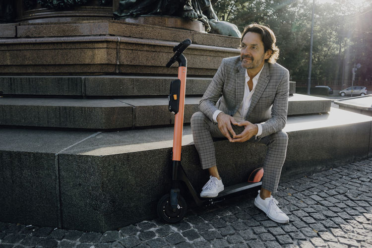 Businessman with e-scooter in the city