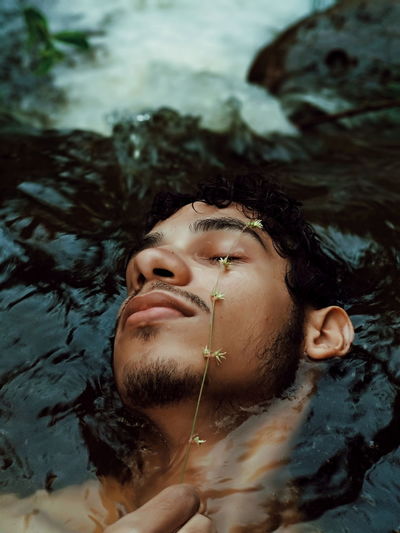 Portrait of young man swimming in water