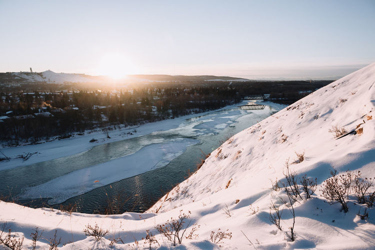 Snowy view of a frozen river at sunset