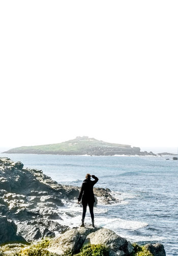 Full length of man standing on beach against clear sky