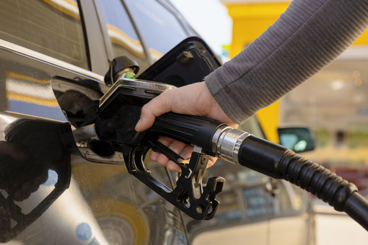 Car refuelling on the petrol station. man refilling the car with fuel. close up view. 
