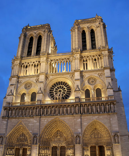 Wide facade of the big basilica of notre dame in paris france by night