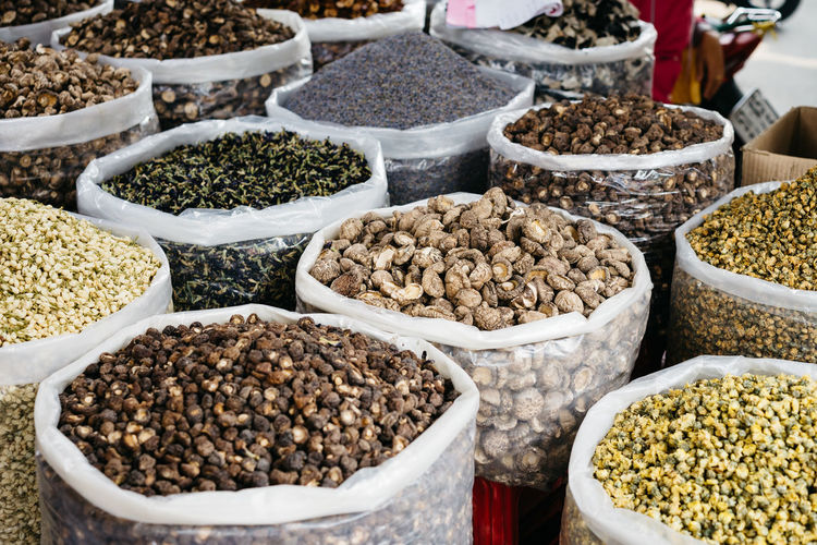 Various spieces and dried vegetables in bags for sale at market stall