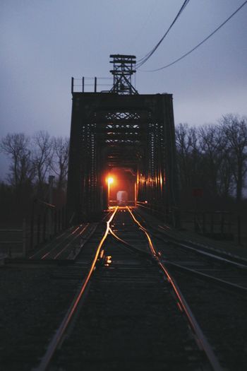 Train at railroad station against sky at night