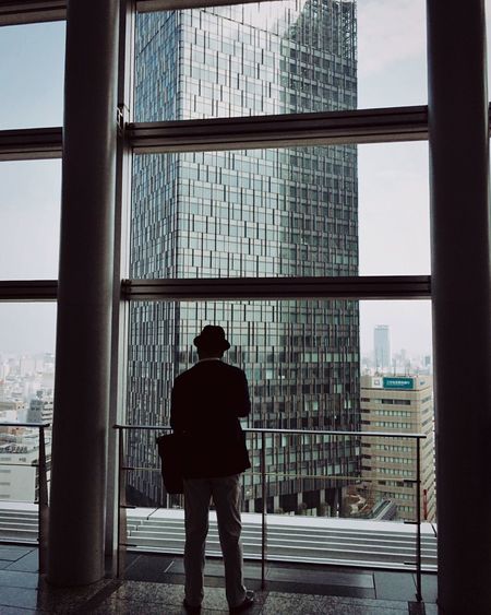 Rear view of well-dressed man standing in building