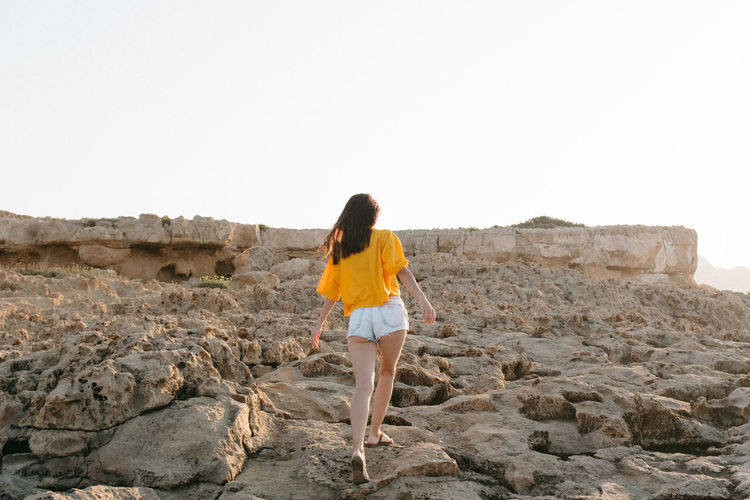 Woman standing on rocky hill in cyprus