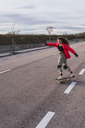 Woman skating with skateboard on road