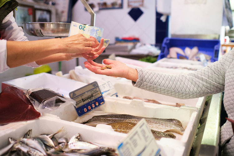 Fishmonger's hands taking money from his client