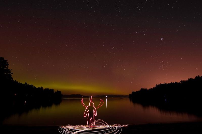 Light painting by lake against star field at night