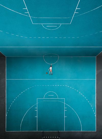 Digital composite image of man lying on basketball court