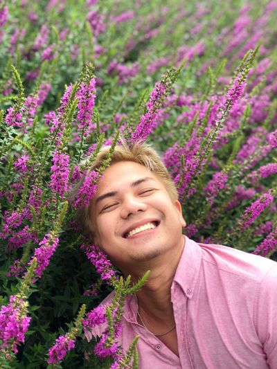 Smiling man by pink flowers
