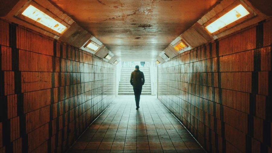 Rear view of person walking through subway