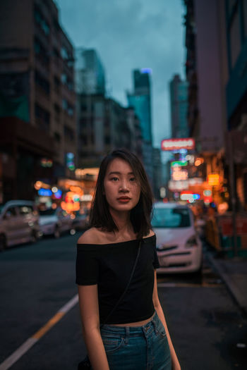 Young woman on city street at night