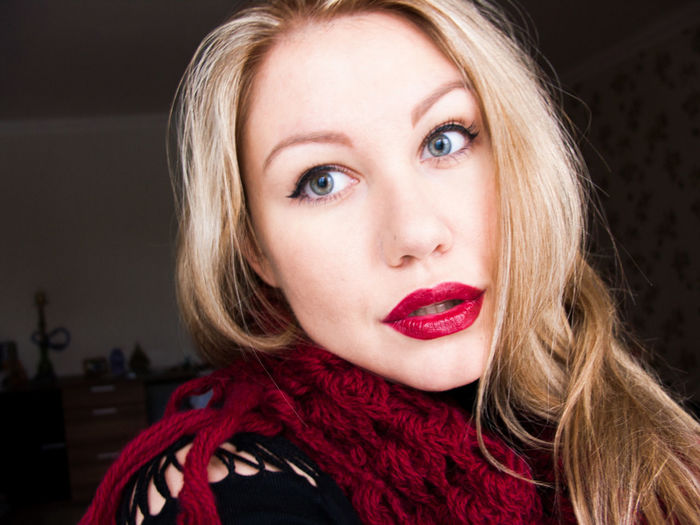 Portrait of beautiful young woman wearing maroon knitted scarf