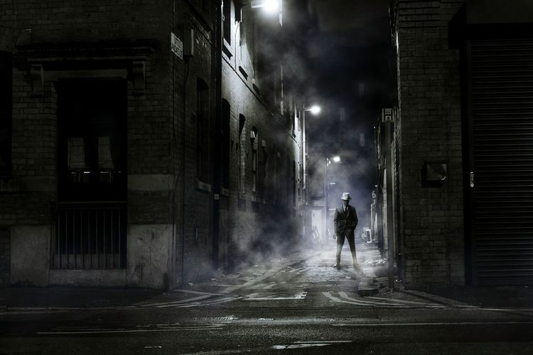 Man standing on street at night