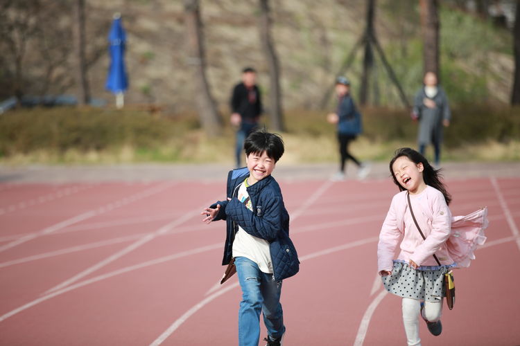 Cheerful friends running on track