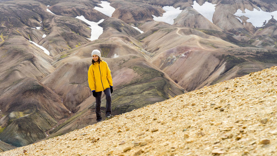 Young woman hiker walking around icelandic highlands and mossy hills