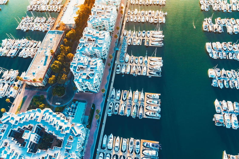 Aerial view of boats moored at harbor by buildings in city