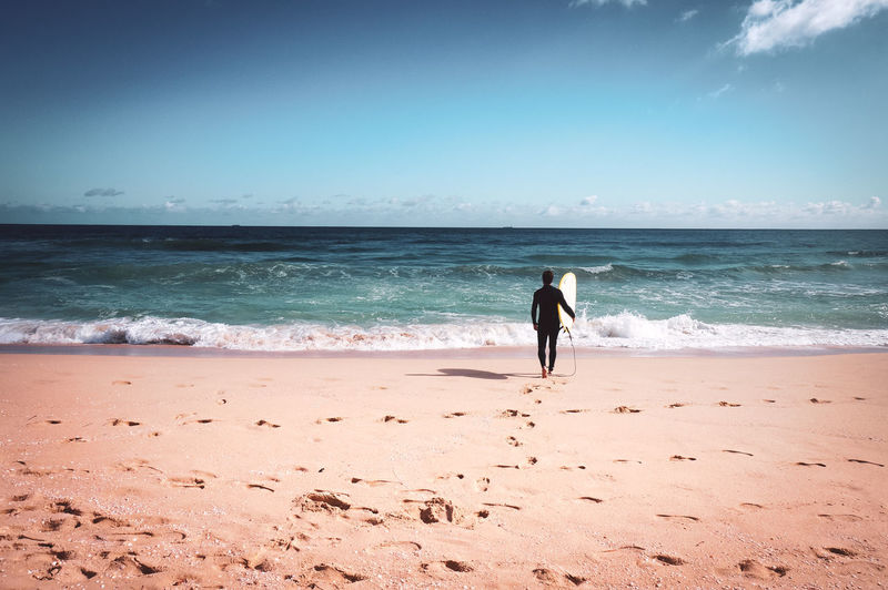 Man walking towards a laurel tree