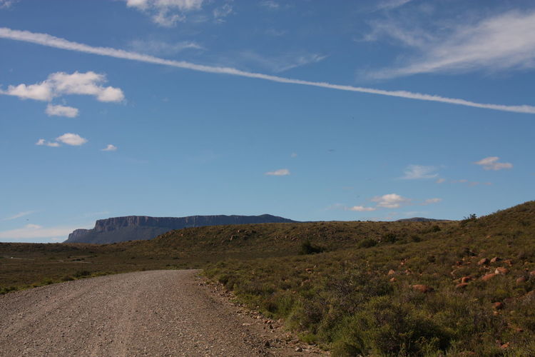 Road amidst land against sky