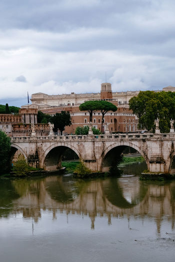 Castelo sant'angelo and ponte sant'angelo over tiber river - cloudy overcast grey day - rome, italy
