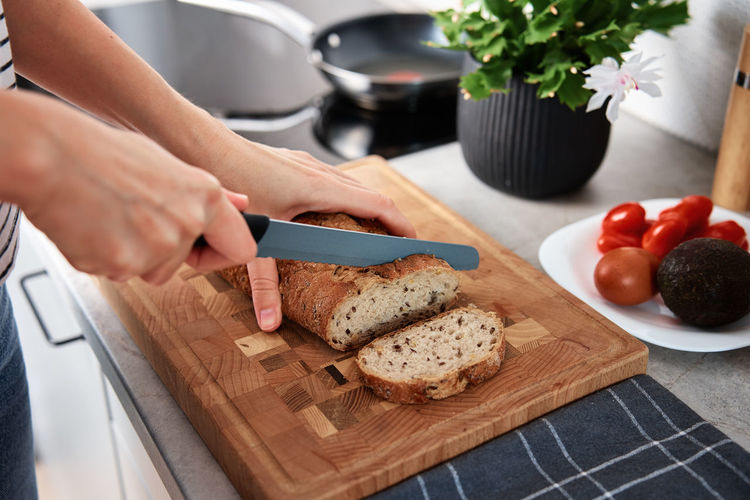 Cropped hand of person preparing food on cutting board