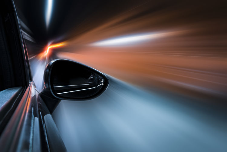 Light trails on side-view mirror. motion blur, electric mobility
