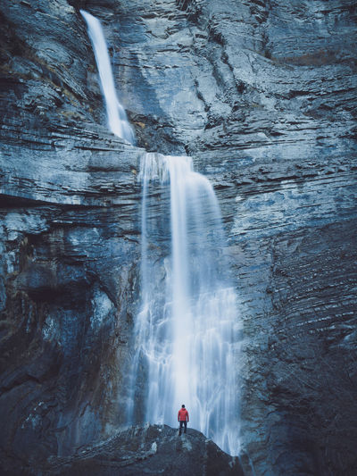 Person standing against waterfall