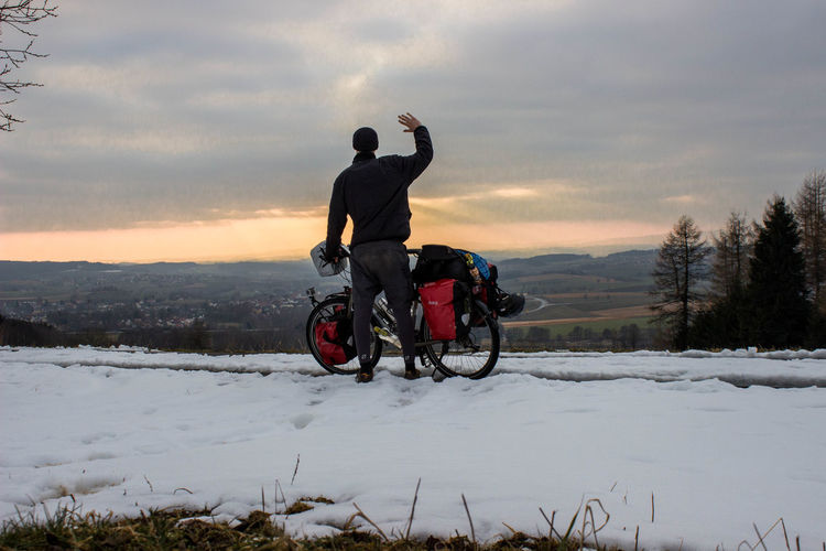 Man riding bicycle on snow covered landscape