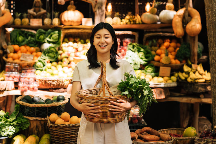 Portrait of woman standing amidst food for sale in market