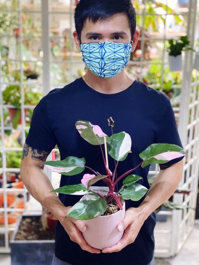 Portrait of man holding plant