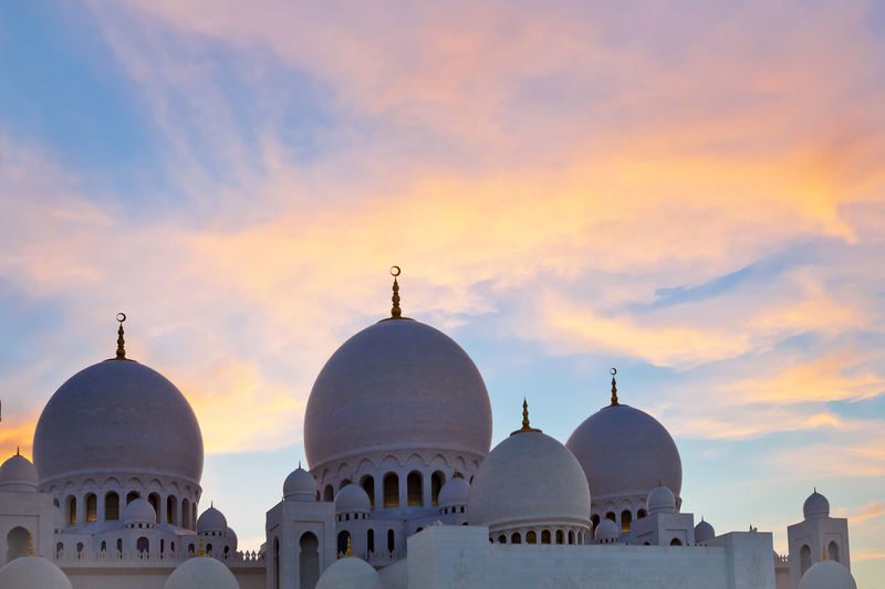 Domes of sheikh zayed grand mosque in abu dhabi at the sunset time