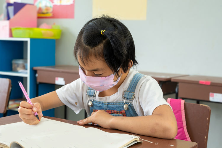 Portrait of an elementary school wearing protective mask to prot