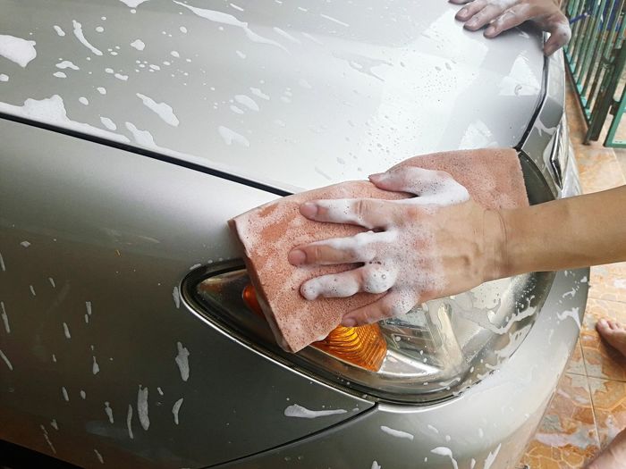 Cropped hands cleaning car