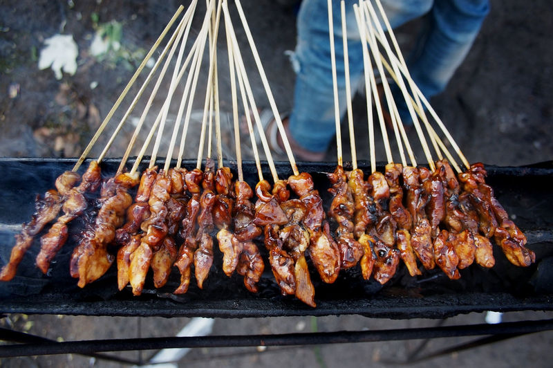 Sidoarjo-indonesia, may 14, 2022. chicken satay is still smoking at the street food stall 