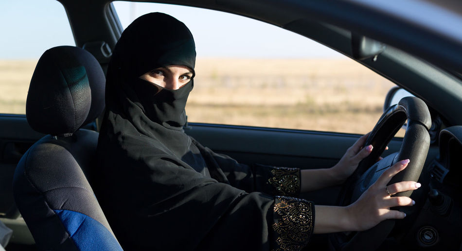 Portrait of woman wearing hijab sitting in car