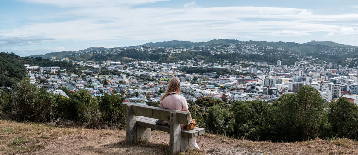Rear view of woman sitting looking over the city of wellington
