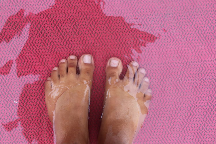 Low section of person standing in water